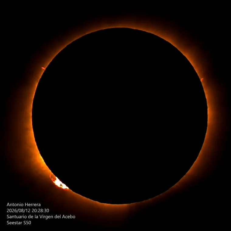 Eclipse total de Sol del 12 de agosto de 2026 fotografiado por Antonio Herrera: la corona y las protuberancias rojas rodean el disco negro de la Luna